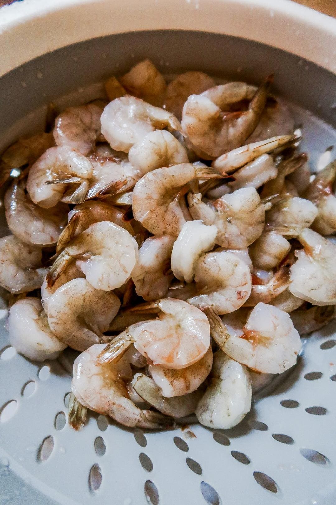 Raw shrimp prepped and rinsed in a colander